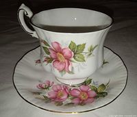 Teacup on saucer showing floral pattern and gold trim