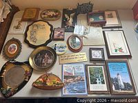 All plaques, signs, plates and prints laid out on table