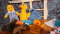 Group shot of all seven stuffed animals on wooden surface