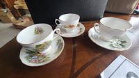 Three Royal Vale teacup and saucer sets on table
