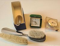 Overview of all items: two clocks, brush with horn, separate horn in sleeve