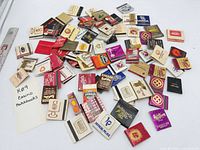 Pile of assorted casino matchbooks spread on table