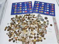 overview of loose coins, two blue albums, note and ruler for scale