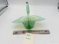 Side view of glass swan dish beside 12-inch ruler showing overall length