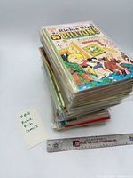 Stack of bagged Richie Rich comics with ruler for scale