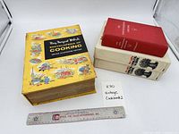 Group shot of four cookbooks with ruler for scale
