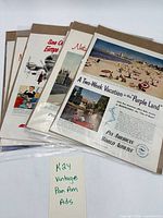Stack of six Pan Am advertisements sealed in sleeves