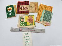Overall view showing five saver books and loose stamp sheets with ruler for scale
