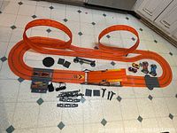 Complete track layout assembled with loops, cars, controllers, power adapter, and accessories visible