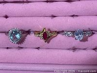 Front view of the three rings showing design, metal tone and gemstone colors