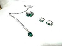 Full view of necklace, ring and earrings on white background