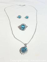 Full view of necklace, ring and earrings showing design and stones