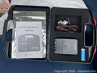 Open case showing TENS 3000 unit, manual, leads, battery