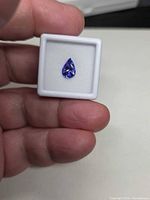 Pear-shaped violet-blue tanzanite in display case