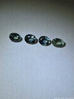 Four oval green-blue sapphires in a row