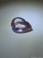 Pear-cut faceted Ametrine showing golden and purple hues