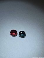 Padparadscha and blue spinel pair on white background