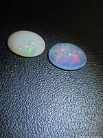 Pair of oval opal cabochons side by side on dark background