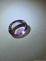 Top view of faceted oval ametrine showing bi-color and facet pattern