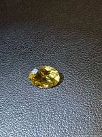 Front view of golden heliodor gemstone on black surface