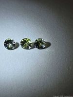 Three round tanzanites side-by-side showing color and cut