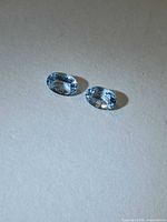 Pair of sky blue oval aquamarines on neutral background