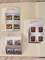 Overview of three Canadian 50¢ art souvenir sheets in album