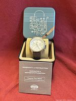 Watch in original tin with booklet visible