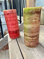 Red and green/brown pillar candles standing on deck
