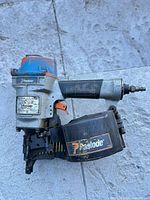 Full view of Paslode pneumatic coil framing nailer with coil magazine attached