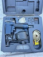 Case open showing nailer, coil nails, hex keys