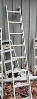 Full view of aluminum ladder leaning against wall