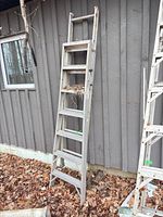 Full view of ladder leaning against exterior wall