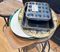 Stack showing muffin tin, rectangular pan and three decorative platters