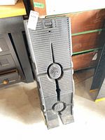 Pair of stacked black plastic car ramps showing textured surface, molded emblem, and wear