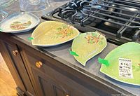 Overview of three Carlton Ware leaf plates and one Limoges dish on countertop