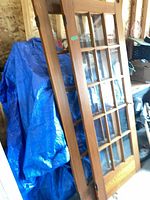 Both French doors leaning, showing glass panes and wood finish