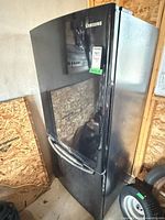 Front view of Samsung black refrigerator showing overall condition
