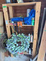 Full view of solid wood three-shelf unit standing against wall