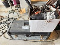 Toolbox closed with cardboard box of tools on top