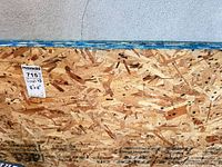 Edge and surface of one OSB sheet with MaxSold tag showing lot number and dimensions