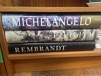 Spines of three large hardcover art monographs: Michelangelo, Raphael, Rembrandt