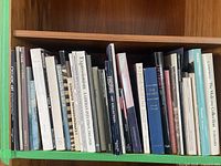 First shelf showing 26 art history books including Cycladic Art, Expressionist Prints, Cy Twombly, The Medici