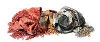 Three plush throw blankets with fringes in rust red, multicolour, and grey-silver tones displayed side by side