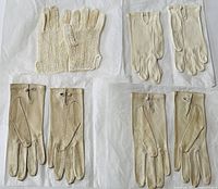 All four pairs of small beige and cream gloves laid out: three leather pairs, one knit pair