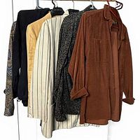 Front view of six assorted blouses on hangers