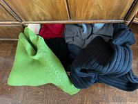 Open dresser drawer showing six assorted colored sweaters