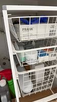 Wire shelf with FRANK gloves box, blue gloves and various small containers