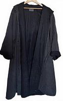 Full view of black Oska coat open on hanger showing length, sleeves, closure, lining