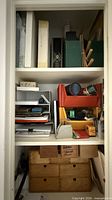 Full closet view showing organizers, binders and wooden drawer unit